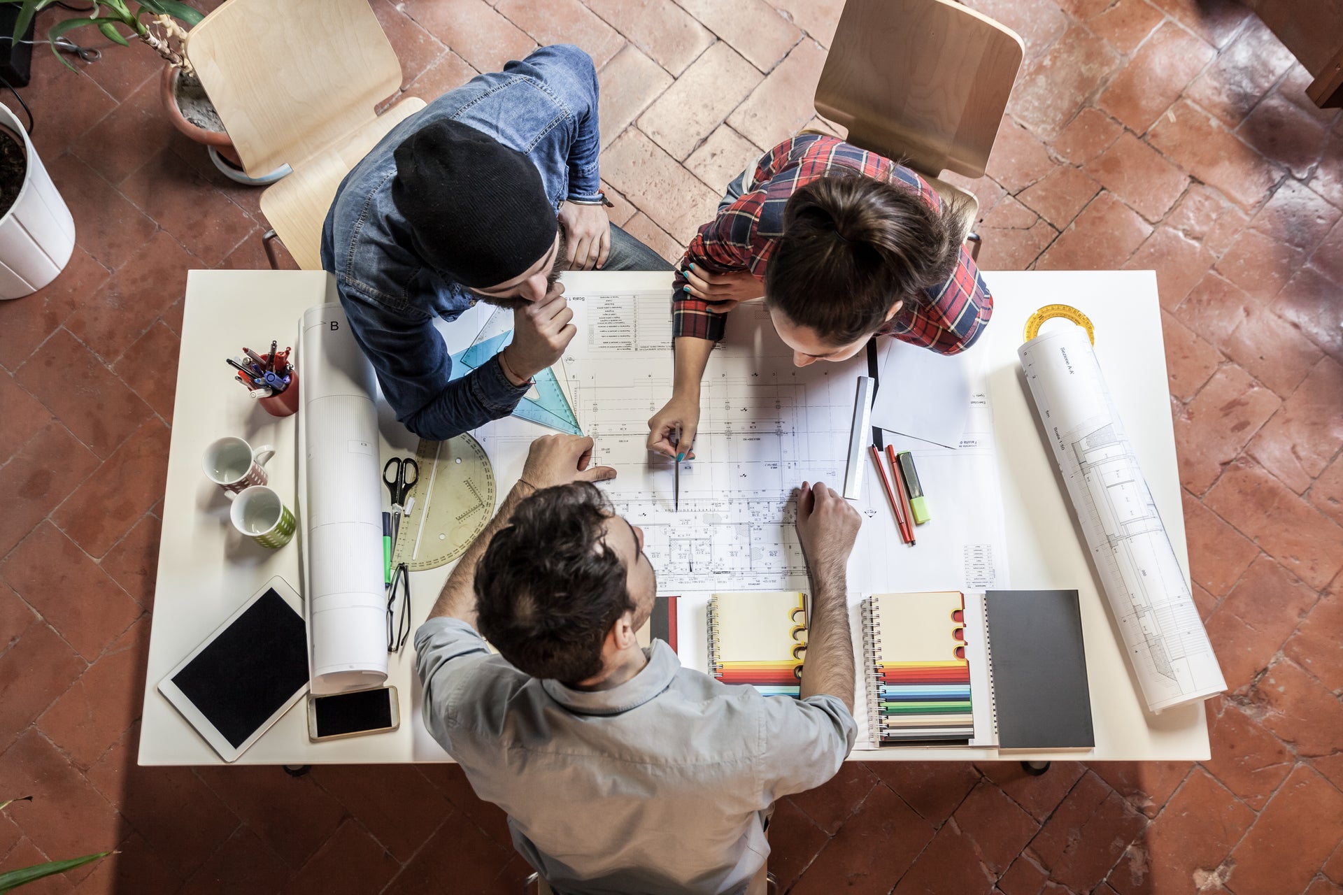 A team of three works over a table.