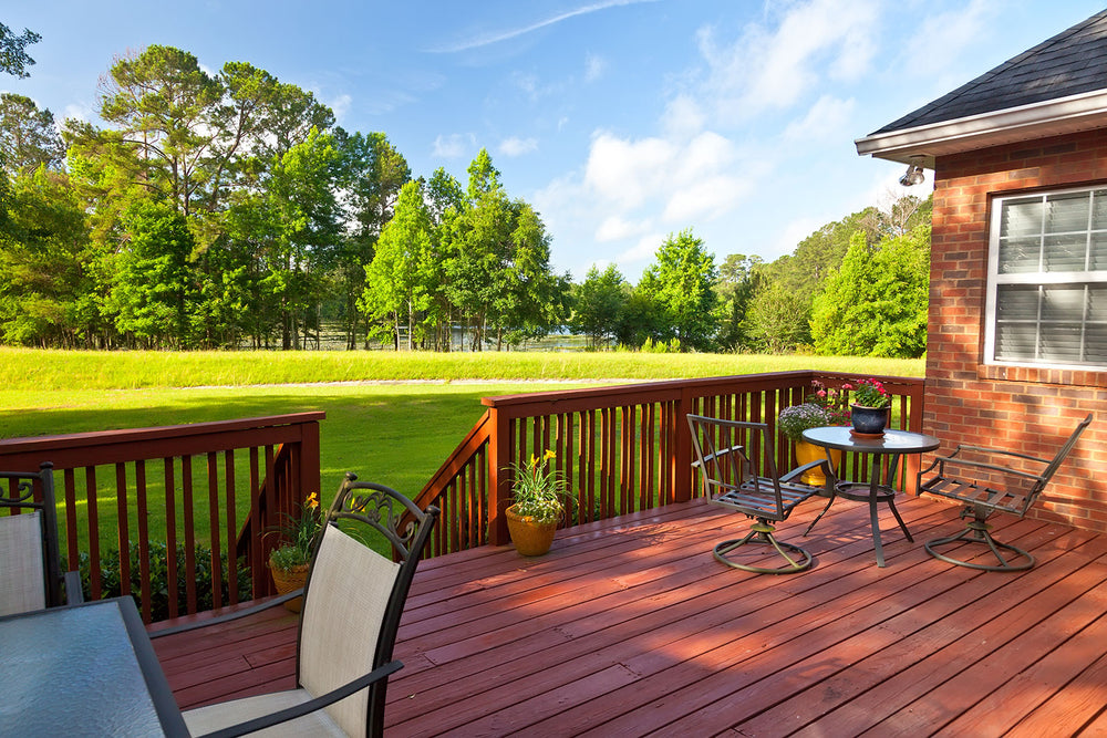 A green backyard with a wooden deck and house in the lower third of the screen.